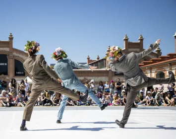 Three dancers perform with their backs turned