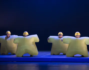 Four dancers wearing inflatable yellow costumes.