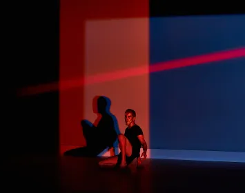 Un bailarín esta sentado, una luz roja 