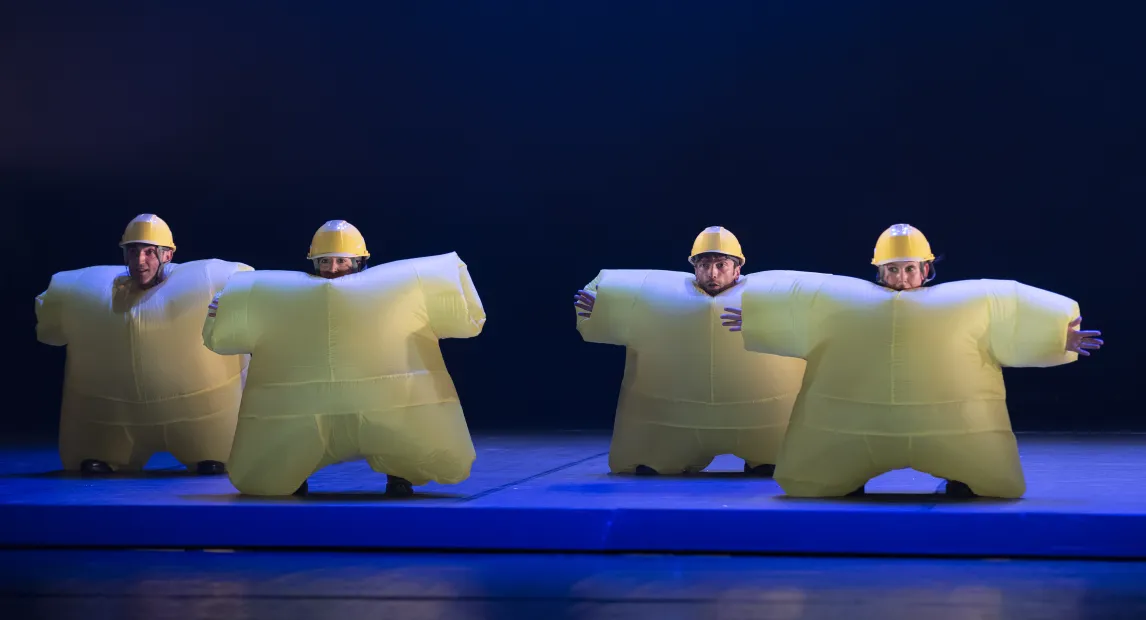 Four dancers wearing inflatable yellow costumes.