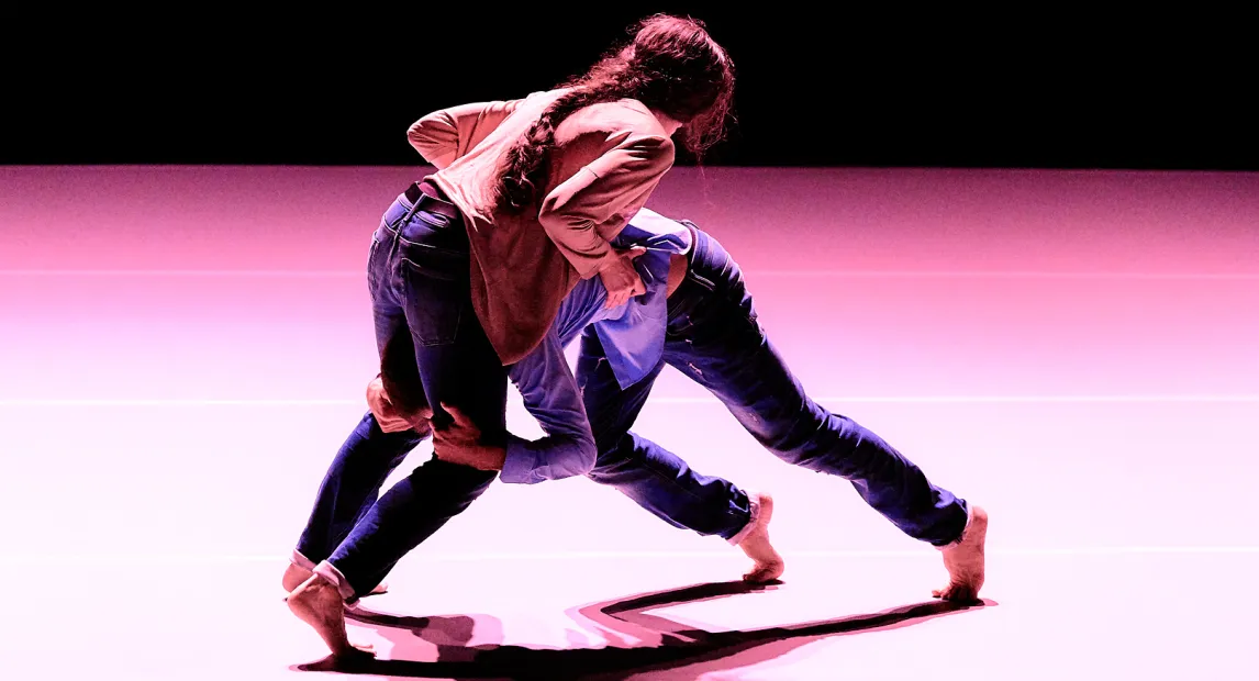 Dos bailarines danzan tiene posición de lucha.