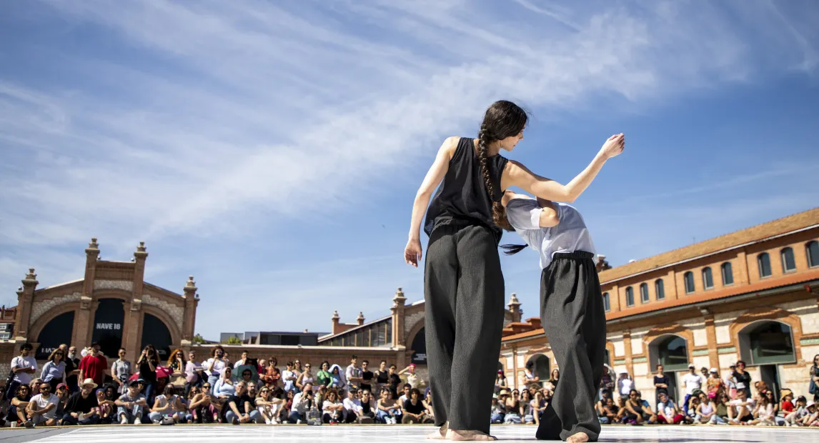 Dos bailarines de espaldas están danzando