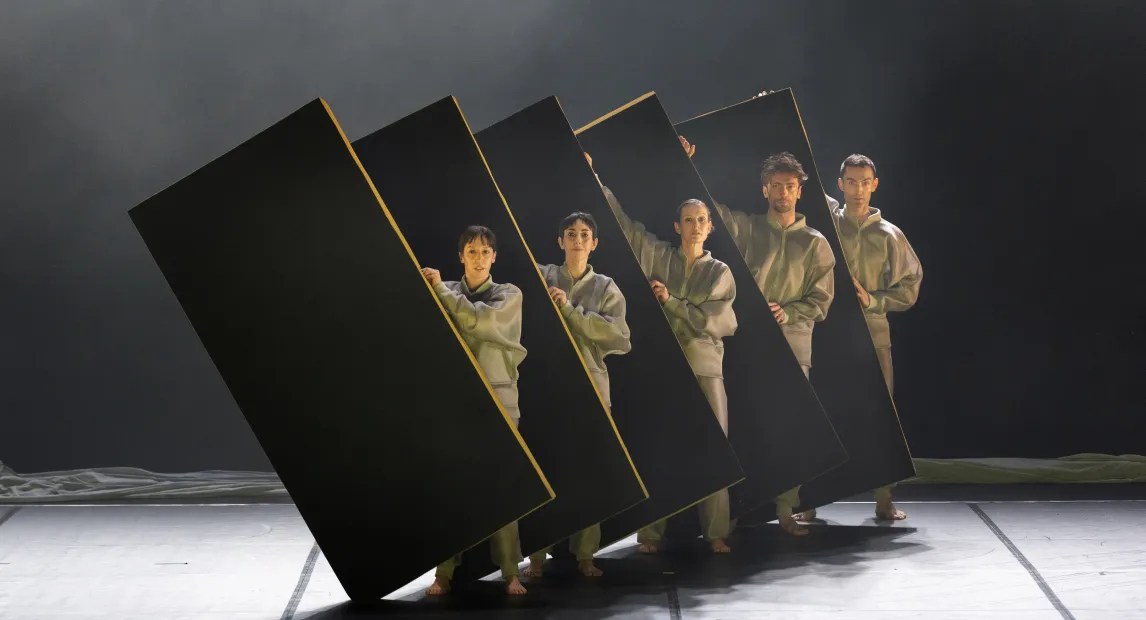 Five dancers perform a coreography.