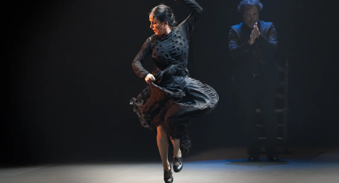 Un mujer danza mientras agarra su falda