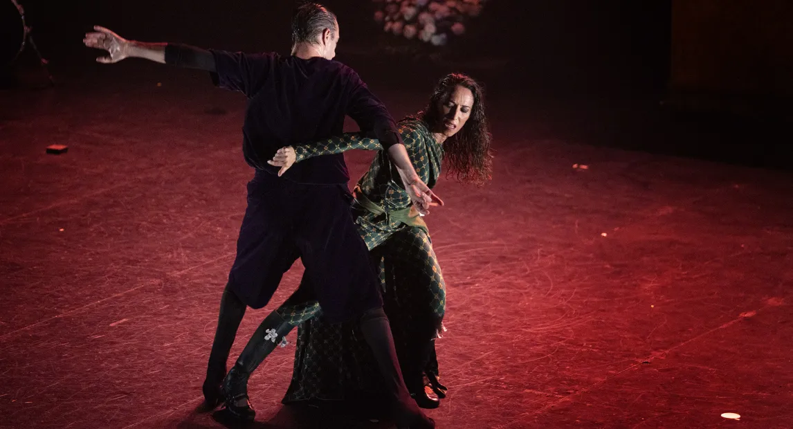 Two dancers perform. The woman has wet hair.