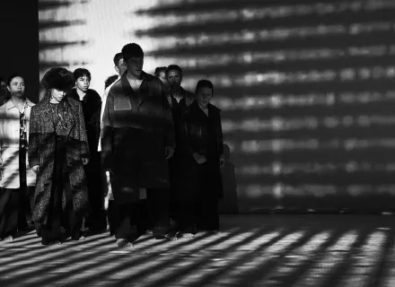 Grupo de personas vestidas con abrigos iluminados a contra luz