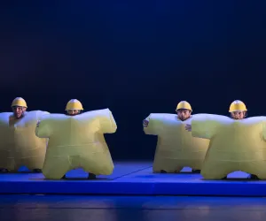 ARACALADANZA LOOP ®Pedro Arnay Four dancers wearing inflatable yellow costumes.