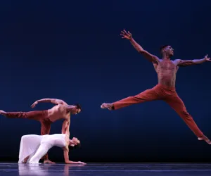 Leslie Andrea Williams and Lorenzo Pagano in Martha Graham’s Diversion of Angels by David Bazemore Tres bailarines danzan , uno de ellos salta y tiene los brazos abiertos.